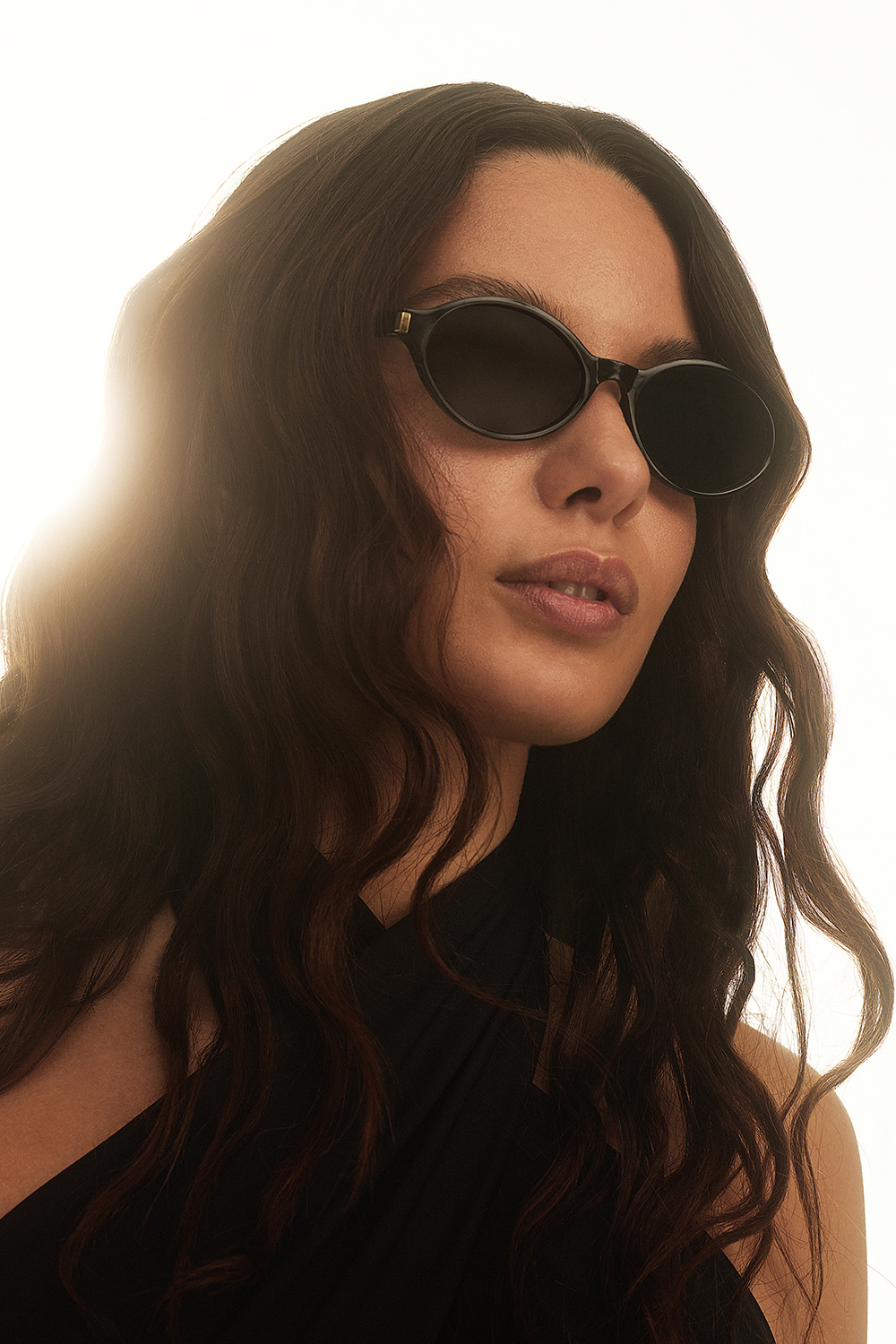 Svarta ovala solglasögon med guldfärgad detalj